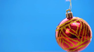 Mavi arka plan üzerinde iplik kırmızı Noel topları dekore edilmiş