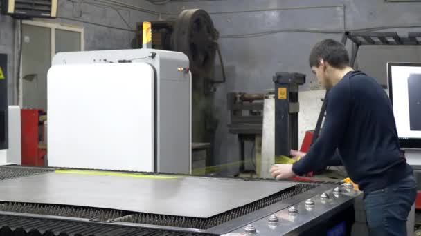 Engineer worker adjusts iron sheet for cutting metal plate on CNC laser machine — Stock Video