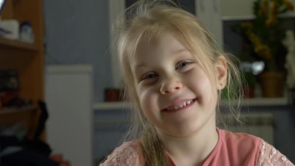 Маленький ребенок со светлыми волосами улыбается — стоковое видео