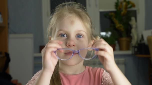 Niña de ojos azules con pelo rubio y gafas — Vídeos de Stock