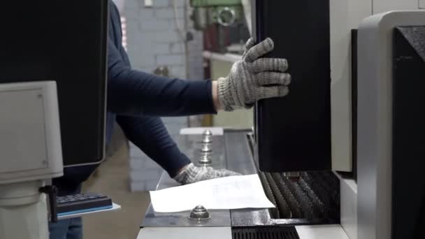 Инженер регулирует машину для резки металлических листов — стоковое видео