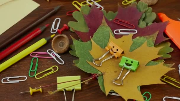 Smiles Binder Clips sobre hojas de arce caidas amarillas y suministros de oficina de la escuela — Vídeos de Stock