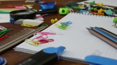Kahverengi ahşap masa üzerinde çok renkli kalemler, kağıt klipler ve Notebook