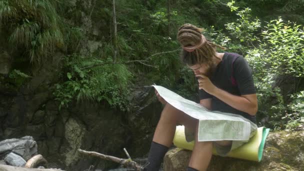 Traveler betraktar karta i skogen — Stockvideo