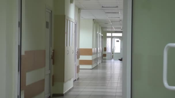 Пустой коридор с зелеными дверями в больнице — стоковое видео