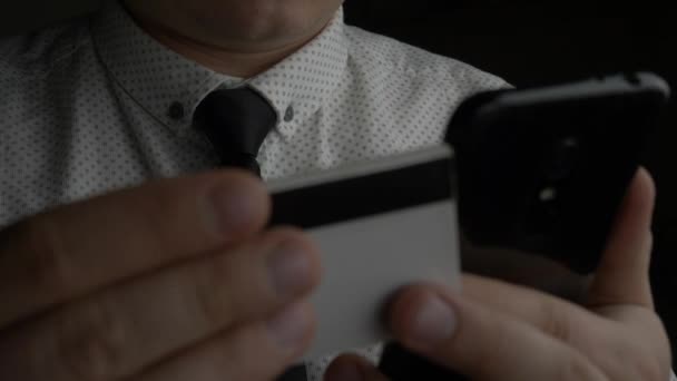 Человек держит кредитную карту с помощью смартфона — стоковое видео