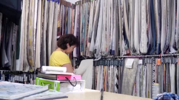 Seamstress parece amostras de tecido para cortinas de costura — Vídeo de Stock