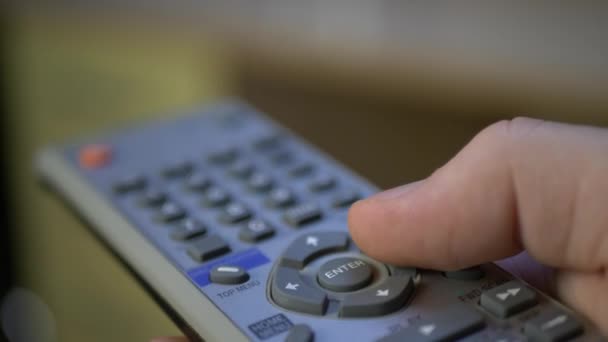 Botones de mano que sostienen el mando a distancia de plata del televisor — Vídeos de Stock