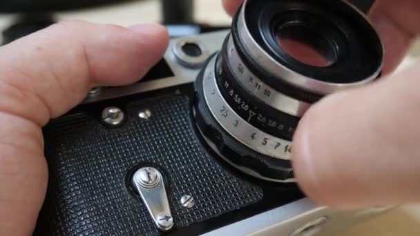 Fotógrafo sostiene cámara analógica y lente — Vídeo de stock