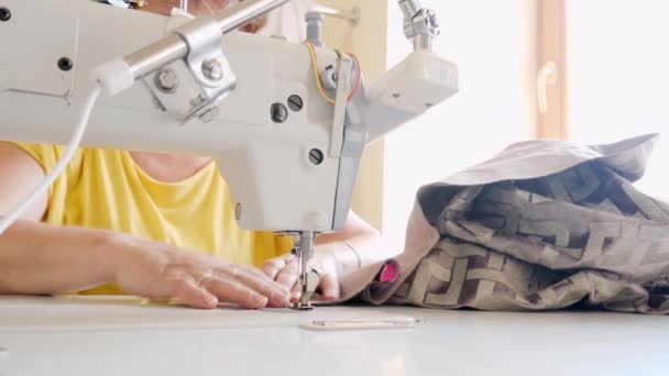 Неузнаваемая пожилая женщина-игла шьет занавески с помощью сшивающей машины — стоковое видео