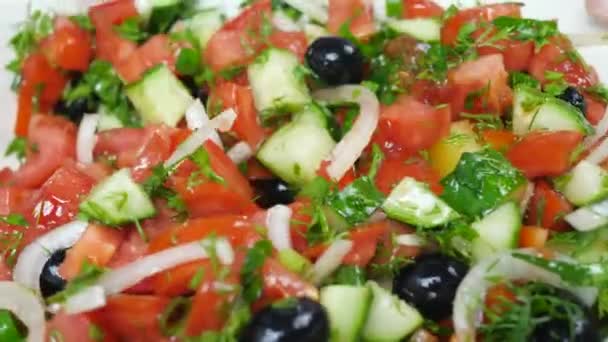 Ensalada con tomate rojo, pepino verde, cebollas y aceitunas — Vídeo de stock
