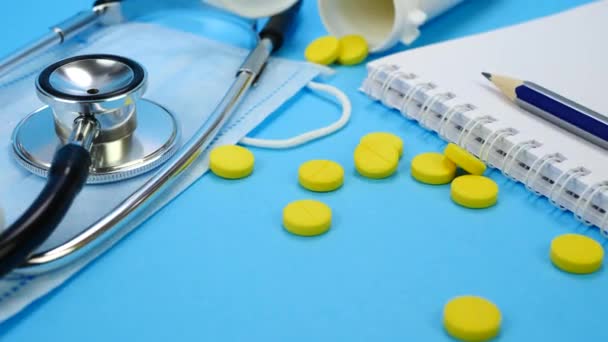 Healthcare and Medical Concept with Yellow Pills, Stethoscope and Paper Notebook — Stock videók