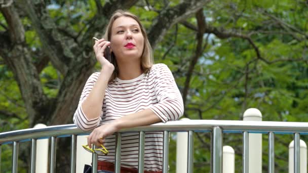 Mujer usando teléfono inteligente negro y tener conversación celular — Vídeo de stock