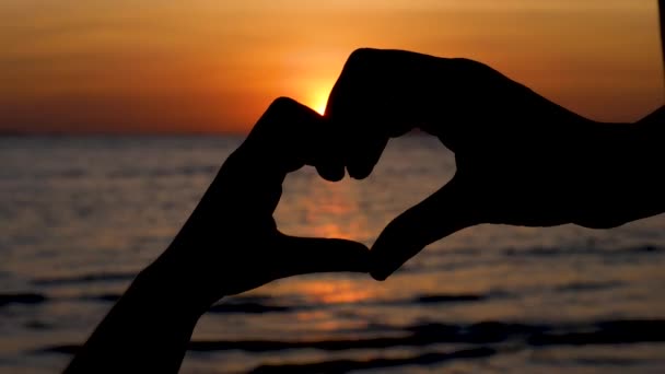 Silhouet van vingers hand in hand van hart op dramatische zonsondergang — Stockvideo