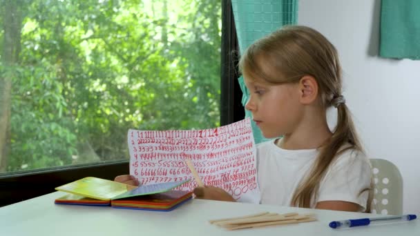 Criança menina faz lição de casa da escola de matemática e contando no ensino fundamental on-line em casa — Vídeo de Stock