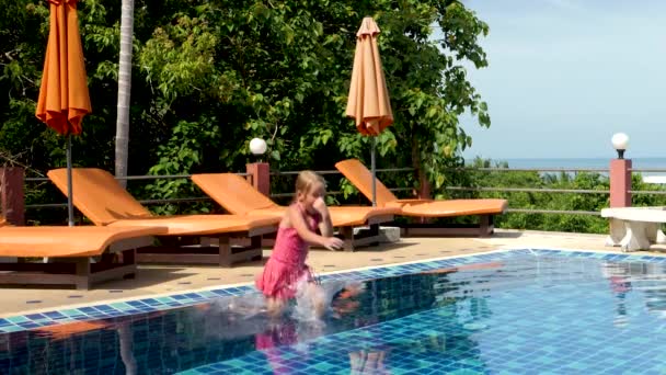 Nettes Mädchen springt und schwimmt im Schwimmbad — Stockvideo