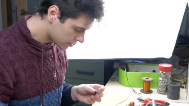 Elektronik İşyerindeki Genç Erkek Tin Lehim Parçaları