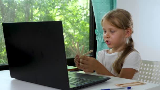 Dziecko dziewczyna patrzeć na laptopa kamery internetowej i dokonać rozmowy wideo — Wideo stockowe