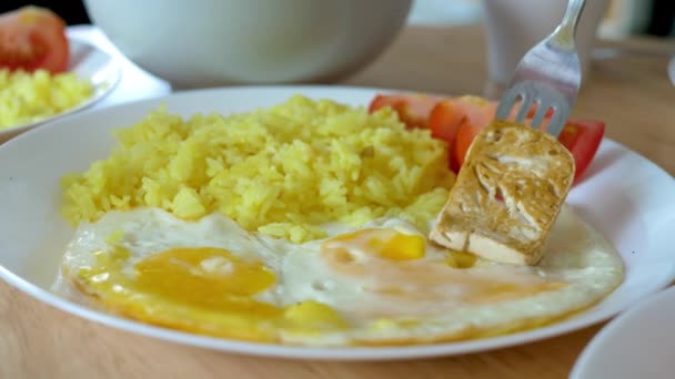 Kurkuma rijstgerecht geserveerd gebakken kippeneieren en tofu of boon wrongel — Stockvideo