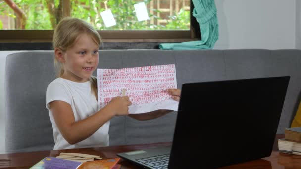 Дитина дивиться на веб-камеру ноутбука і робить відеодзвінок — стокове відео