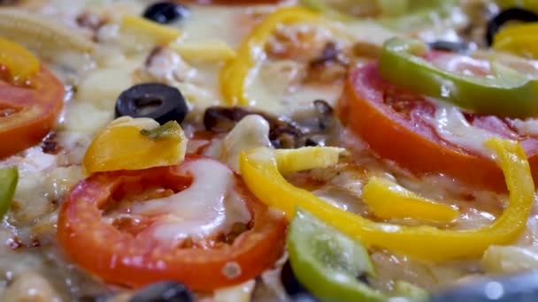 Гаряча піца з курячим м'ясом, сиром, нарізаними помідорами та чорними оливками — стокове відео