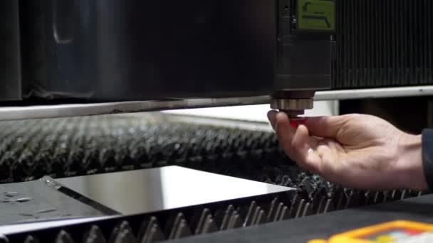 La mano de los ingenieros ajusta la máquina láser CNC para cortar la placa de metal — Vídeos de Stock