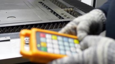Mühendislerin elleri CNC lazer makinesini metali kesmek için ayarlıyor