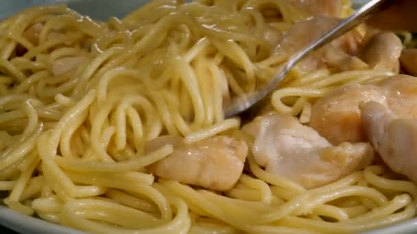 Fork take cooked noodles with chicken meat in plate — Stock Video