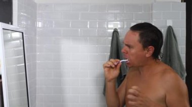 Yakışıklı erkek fırça dişleri, şarkı söylemek, dans etmek ve banyoda eğlenmek.