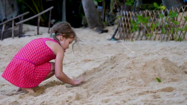 Kleines Mädchen am tropischen Strand baut Sandburg — Stockvideo