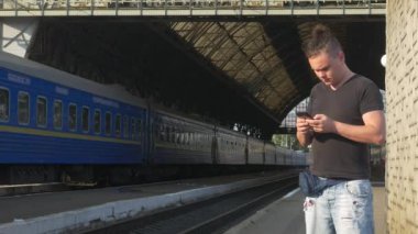 Tren İstasyonunda Akıllı Telefon Kullanan Gezgin 