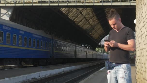 Reiziger Smartphone gebruiken op het treinstation — Stockvideo