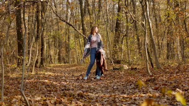 Glückliche junge Mutter und schöne Tochter spielen im Herbstpark — Stockvideo