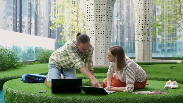 Jovem colega de trabalho adulto trabalha com laptop na grama verde no escritório espaço de co-trabalho — Vídeo de Stock