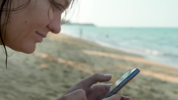 Mani femminili utilizzando smartphone nero su sfondo acqua di mare — Video Stock