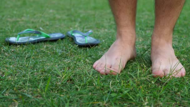 Barefoot Man verschuift van de ene voet naar de andere op groen gras — Stockvideo