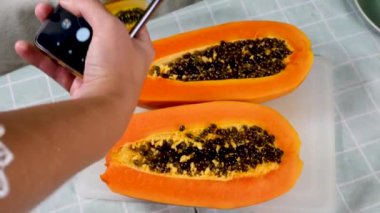 Olgun papaya hamuru meyvesinin fotoğrafını çekiyor.