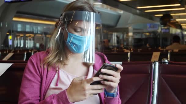 Kvinna i medicinsk mask och ansiktsskydd på flygplatsen — Stockvideo