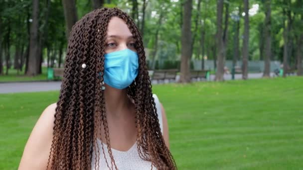 Mladá dospělá žena v ochranné masce kýchnout na veřejnosti mimo — Stock video