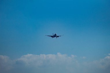 Yolcu jeti bulutlu açık mavi gökyüzüne doğru uçuyor. Seyahat, havacılık, hız ve özgürlük kavramı.