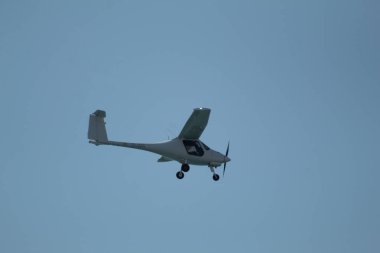 Kıbrıs Rum Kesimi 'nin Larnaka kenti yakınlarındaki Akdeniz üzerinde açık mavi bir gökyüzünde iki koltuklu hafif uçak süzülüyor. Seyahat, tatil ve havacılık temaları için mükemmel.