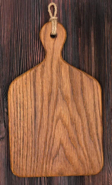 Wooden oak cutting board on a old rustic surface, top view, clos