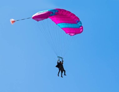 Mavi gökyüzü arka planı ndaki paraşütçüler. Tandem paraşüt. 