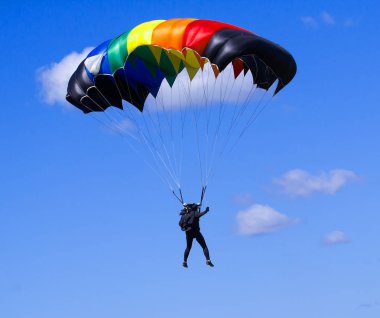 Mavi bir gökyüzü bac üzerinde çok parlak renkli paraşüt ile Skydiver