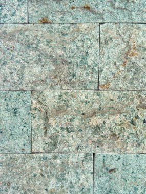 Dokulu yeşil ve gri taş duvar yüzeyi mimari ve tasarım projeleri için serin ve modern bir zemin sunuyor.