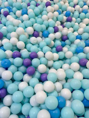 Canlandırıcı mavi, beyaz ve mor renkli renkli oyun toplarının canlı bir koleksiyonu çocukların aktiviteleri için neşeli, neşeli bir atmosfer yaratıyor..