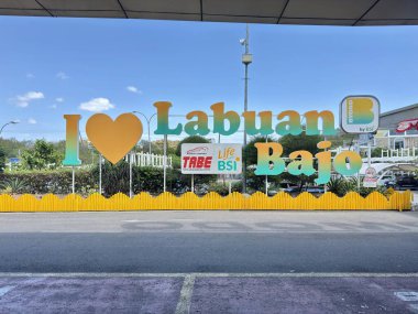 Discover vibrant 'I Love Labuan Bajo' landmark sign inviting tourists to explore stunning Indonesian coastal beauty and adventure