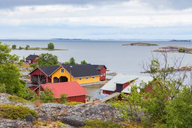 Finlandiya 'nın samimi bir balıkçı köyünde, Baltık Denizi' nin sularında ahşap tekne kulübelerinin güzel manzarası. Geleneksel İskandinav mimarisi ve huzurlu kıyı yaşam tarzı