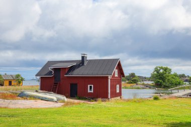 Finlandiya 'nın samimi bir balıkçı köyünde, Baltık Denizi' nin sularında ahşap tekne kulübelerinin güzel manzarası. Geleneksel İskandinav mimarisi ve huzurlu kıyı yaşam tarzı