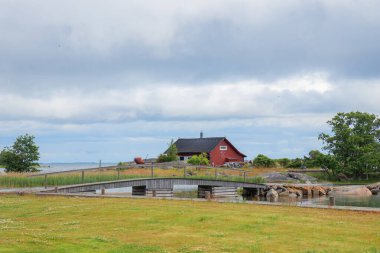 Finlandiya 'da manzaralı ahşap kulübe. Geleneksel İskandinav mimarisi, rahat kırsal atmosfer, doğa, huzurlu manzara ve kuzey cazibesi ile çevrili.